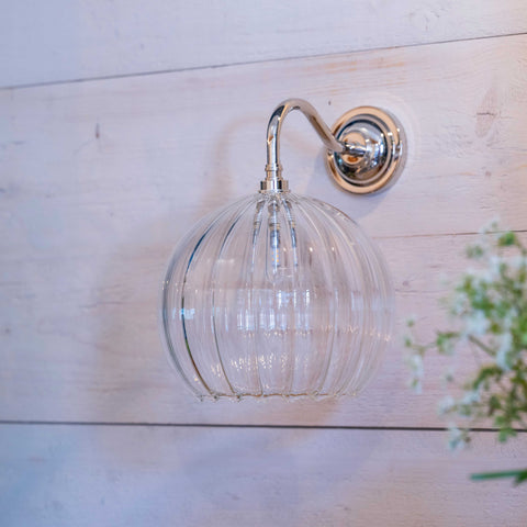 Soho large ribbed glass shade bathroom wall light with polished metal mount on white wooden wall