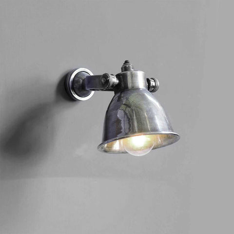 Kelston Adjustable Spotlight wall light with antique silver finish and curved domed shade mounted on gray wall