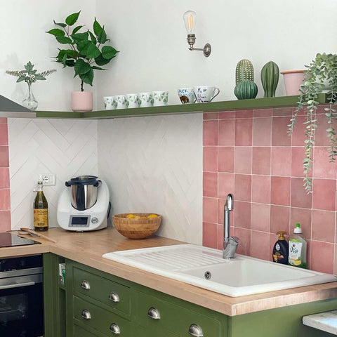 Kennet Adjustable Wall Light in industrial style with exposed bulb mounted above kitchen sink and green cabinetry