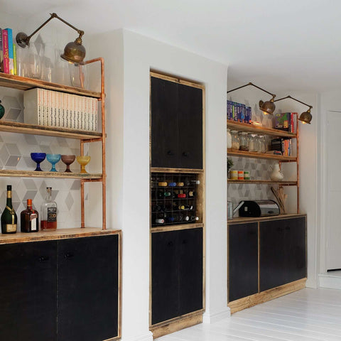 Dale Adjustable Wall Light mounted above shelves illuminating books and decor in a modern room