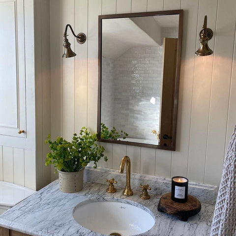 Kent Adjustable Wall Light mounted above bathroom mirror with brass finish and classic design