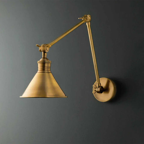 Pooky Stork Wall Light adjustable brass wall lamp in antique finish mounted on dark gray wall