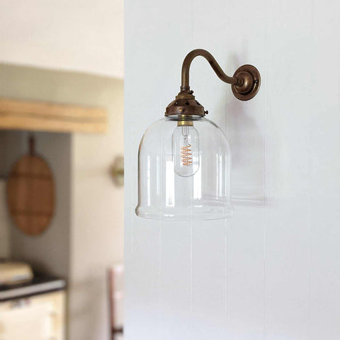 Hythe small clear glass shade wall light with bronze curved arm and exposed filament bulb