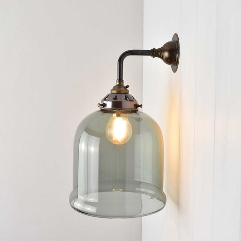 Hythe Small Smoked Glass Shade Wall Light with a warm, elegant smoked glass shade and antique bronze fixture mounted on a wall