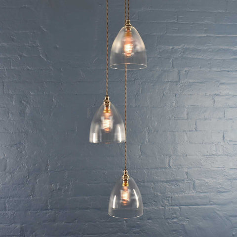Margate Small Ribbed glass shade cluster pendant light with three ribbed glass shades hanging against a blue brick wall