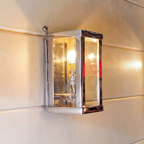 Chiswick Outdoor Wall Light small polished brass with glass panels mounted on exterior wall emitting warm light