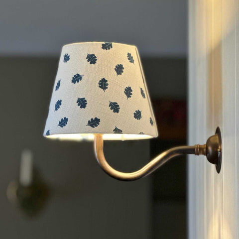 Finberry Blue Oak Leaf fabric shade wall light with brass arm and leaf pattern design