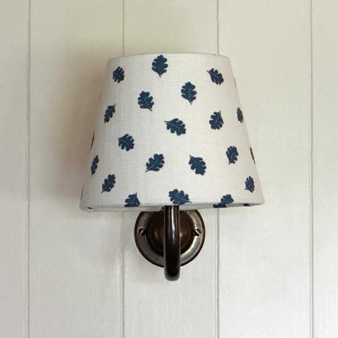 Finberry Blue Oak Leaf fabric shade wall light with blue oak leaf pattern on white linen and solid brass fittings.