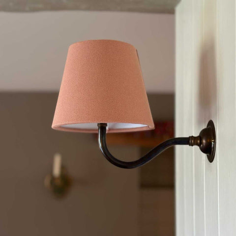 Finberry Pink Linen fabric shade wall light with brass swan neck fitting mounted on wall
