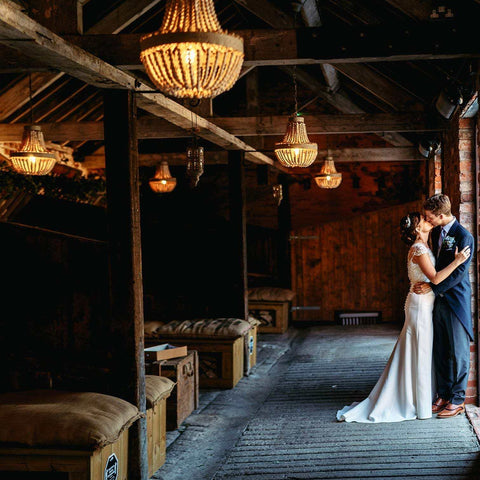 Beaded Pendnat lights hanging in wedding venue above bride and groom. 