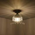 Bodium small ribbed glass shade flush ceiling light with flower-inspired design casting ambient light patterns.