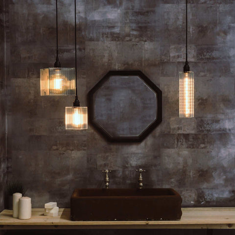 Bramley Bathroom reed glass long pendant lights with warm filament bulbs over dark sink and rustic wall