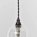 Small clear glass bathroom pendant light with adjustable cord and black metal fitting