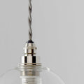Small clear glass bathroom pendant light with silver metal fittings and adjustable braided cable