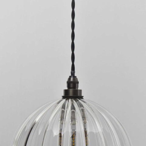 Soho Medium Ribbed Glass Shade pendant light with clear ribbed glass and black twisted cord suspended against a light gray background.