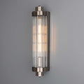 Louise Bathroom Wall Light with art deco design and elegant reeded glass, emitting a warm glow on a gray wall.