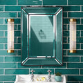 Pooky Long Roddy bathroom wall lights with glass rods and brass finish on green tiled wall by mirror and sink