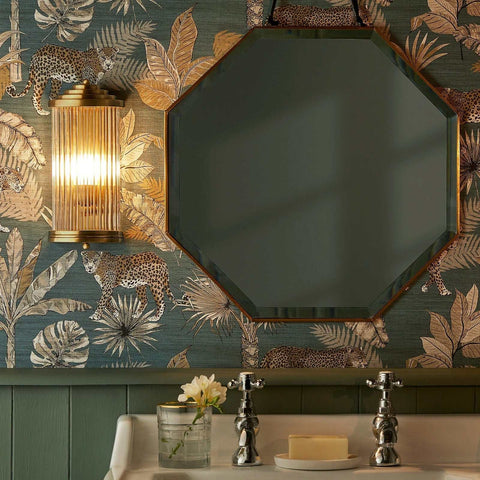 Baby Roddy Bathroom Wall Light with clear glass rods and polished semi-circular fitting mounted beside an octagonal mirror in a stylish bathroom.
