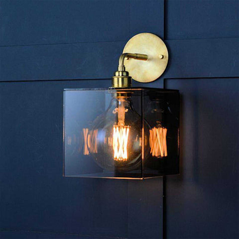 Bramley Bathroom smoked glass globe wall light with brass mount and dimmable LED filament bulb on dark wall