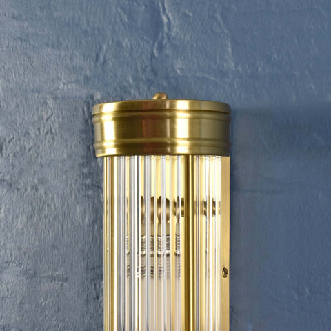 Brass wall-mounted light fixture against a blue wall
