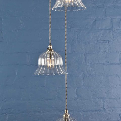Bodium small ribbed glass shade cluster pendant light with clear ribbed glass and metal fittings against a blue brick wall