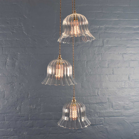 Bodium Large Ribbed Cluster Pendant Light with three clear ribbed glass shades hanging against a grey brick wall