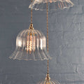 Bodium Large Ribbed Cluster Pendant Light with handcrafted ribbed glass shades and vintage-style filament bulbs against a textured gray wall