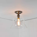 Bodium medium clear glass shade flush ceiling light with hand-blown bell glass design and antique bronze finish, ideal for low ceilings.