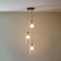 Brook Small Ribbed Glass Shade Cluster Pendant Light with three hand-blown ribbed glass shades and adjustable cords in a modern dining room setting