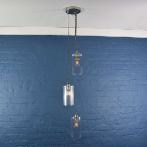 Brook Small Ribbed Glass Shade cluster pendant light with three hand-blown frosted glass shades hanging from twisted cords in a minimalist room