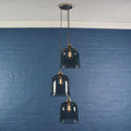 Hythe Medium Smoked Glass Shade cluster pendant light with three hand-blown bell-shaped smoked glass shades against blue wall