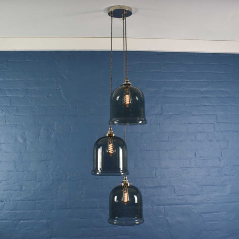Hythe Medium Smoked Glass Shade cluster pendant light with three hand-blown bell-shaped smoked glass shades against blue wall