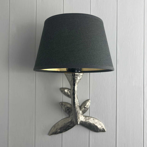 Laurier Wall Light with bronze leaf design and black fabric shade mounted on white paneled wall