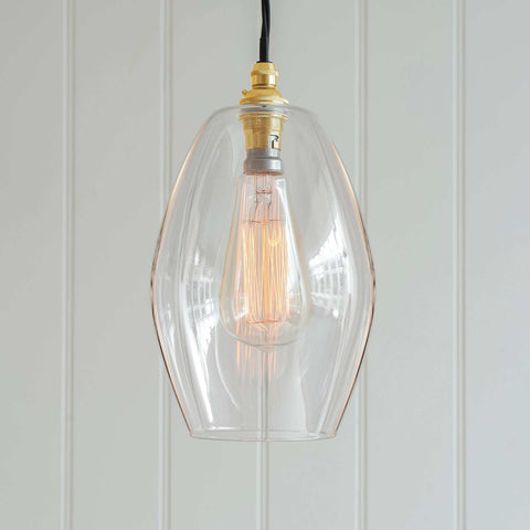 Wonky Camber clear glass pendant light with a vintage bulb and brass fittings, showcasing a unique fluted design.
