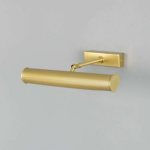 Cambridge Adjustable Brass Picture Light in reeded antique brass finish illuminating artwork