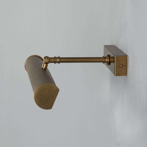Cambridge Adjustable Brass Picture Light in Antique Brass illuminating framed artwork