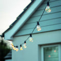 Solar festoon 20 bulb string lights in black for outdoor use with warm white LED bulbs and solar power.