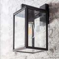 Belgrave Outdoor carriage light with powder-coated steel frame and glass panels in off-black finish mounted on exterior wall