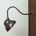 Fairburn IP23 Wall Light with curved metal arm and retro cap-style lamp mounted on wooden exterior wall