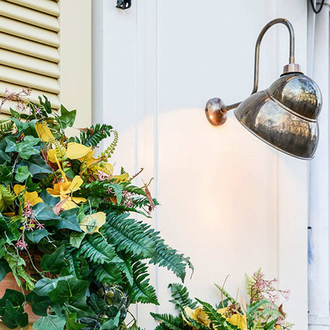 Fairburn IP23 Wall Light vintage-style outdoor metal wall lamp illuminating porch with plants
