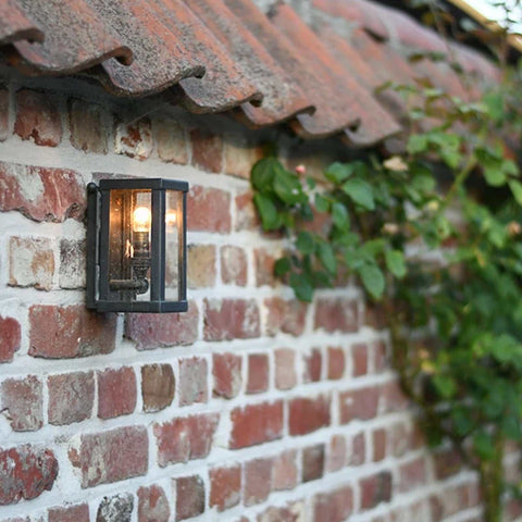 Chiswick Outdoor Wall Light small cast brass fixture mounted on brick wall illuminating outdoor garden area