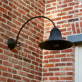 Kew Outdoor Wall Light large bronze curved arm mounted on brick exterior wall illuminating outdoor space