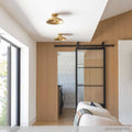 Telal Flush Ceiling Light in vintage brass finish installed in a modern hallway with wooden accent wall and sliding glass door.