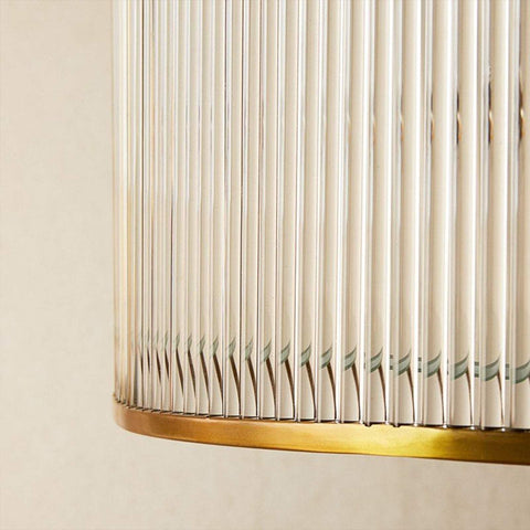 Close-up of Artemis Chandelier pendant light showing brass frame and clear glass rods detail.
