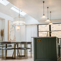 Pooky Artemis Chandelier pendant light with brass frame and glass rods in modern dining room setting