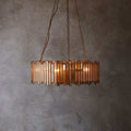 Pooky Melvillous Chandelier pendant light with mercerised glass and art deco design hanging against a textured wall