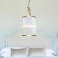 Pooky Valli Pendant Light with brass finish and glass rod lantern design hanging above bed in bedroom