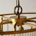 Close-up of brass oval frame and suspension detail of the Loki Two-Tiered Oval Chandelier with glass rods