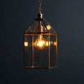 Pooky Carrington Lantern large vintage brass pendant light with glass panels and warm glowing filament bulb