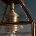 Close-up of Pooky Carrington Lantern large vintage brass pendant light with glass panels and detailed metalwork